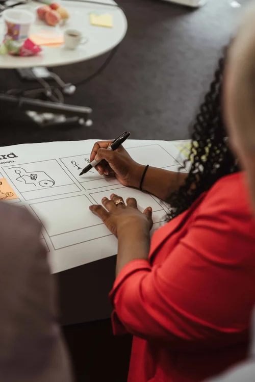 Hands sketching a storyboard template during a design workshop